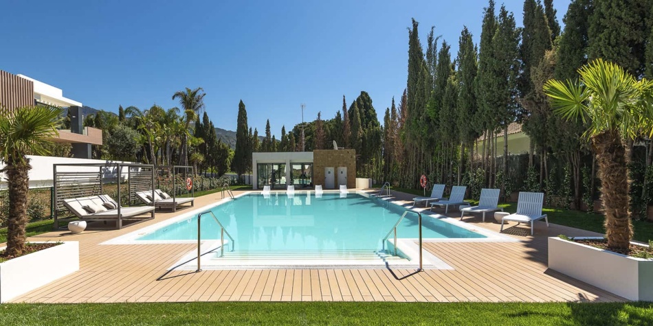 Pool area from another point of view. Sunbeds, grass and crystal clear water